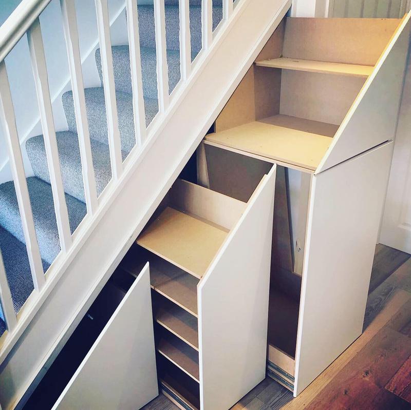 Bespoke under-stairs pull-out drawers and shelving in a painted staircase