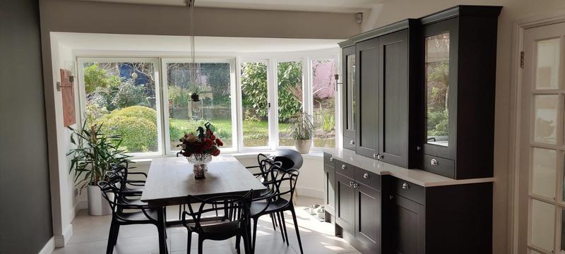 Dining area in a curved bay window overlooking a mature garden