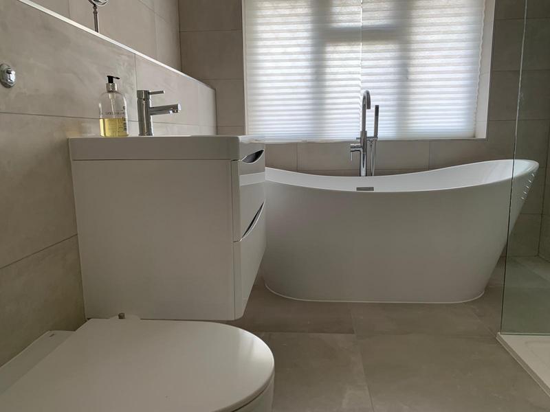 Grey tiled bathroom with a freestanding bath, walk-in shower and back-to-wall WC