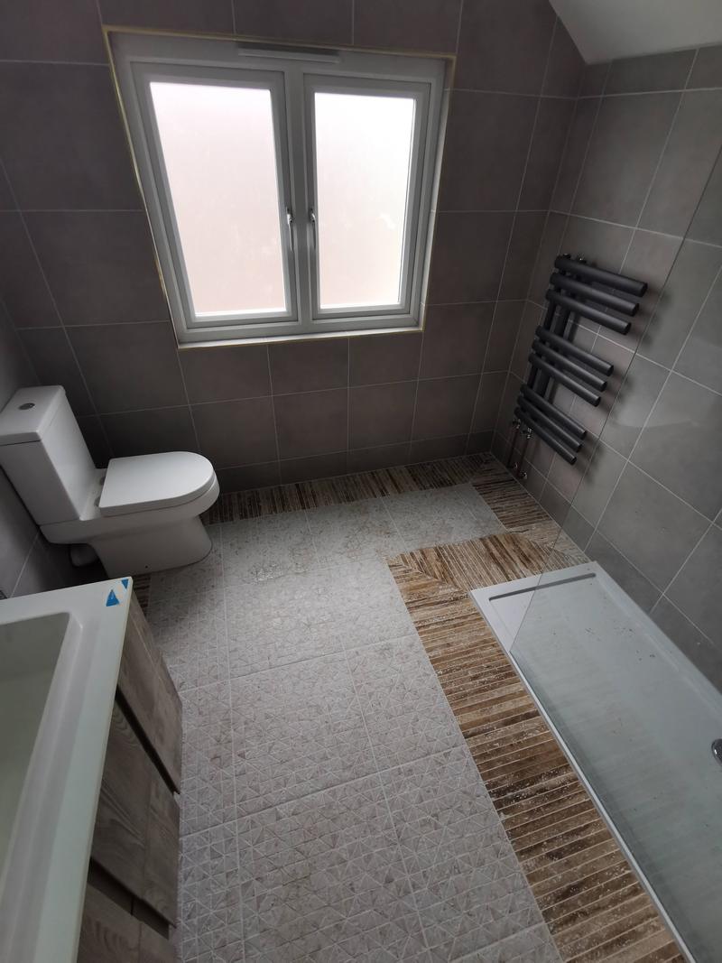 Loft bathroom with a bath, WC and anthracite ladder towel radiator under a sloping ceiling