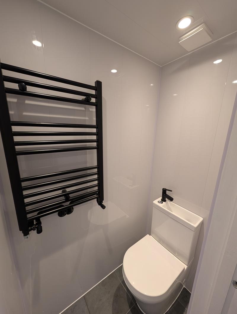 New downstairs cloakroom with a black ladder towel radiator and matching tap