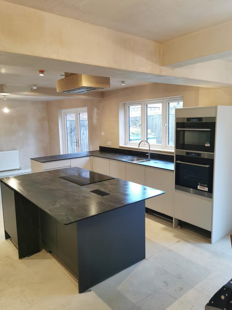 New kitchen with a large island and slate-effect worktops, fitted before final decoration