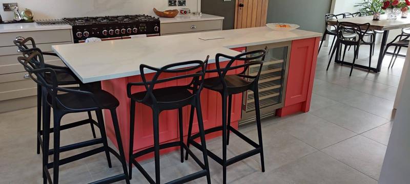 Open-plan kitchen island with bar stools facing a range cooker