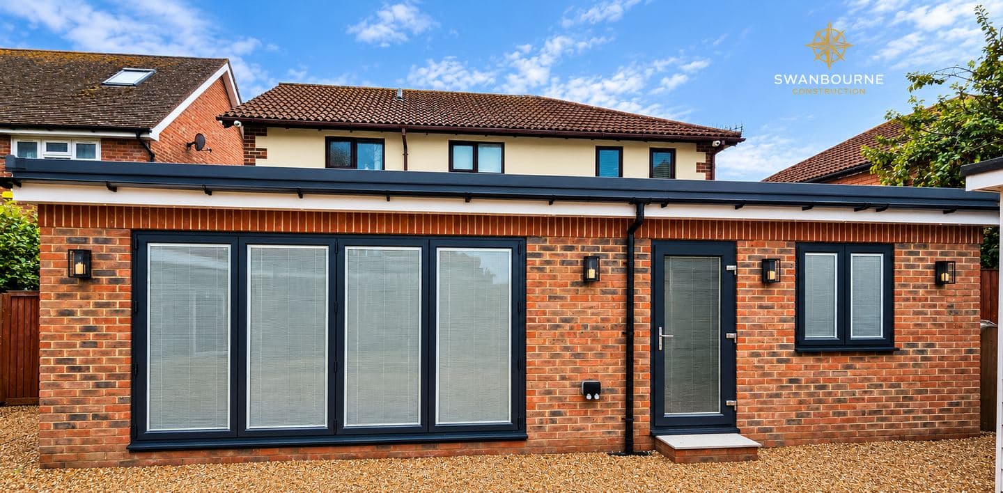 Finished 50 square metre rear extension in Bognor Regis by Swanbourne Construction: red brick with a soldier course, anthracite bifold doors and a flat roof