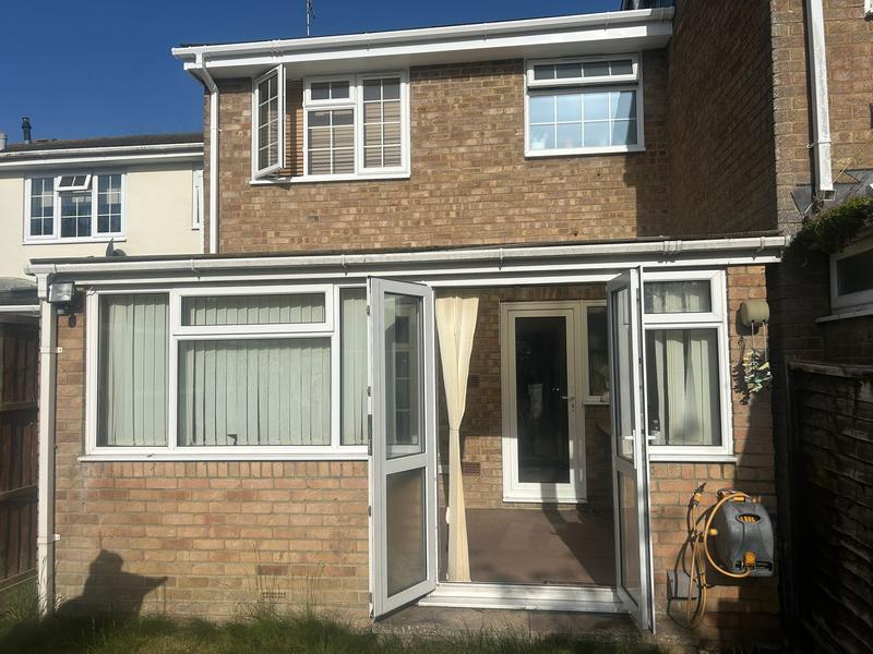 Rear of a brick house with an old flat-roof lean-to sun room, before work started