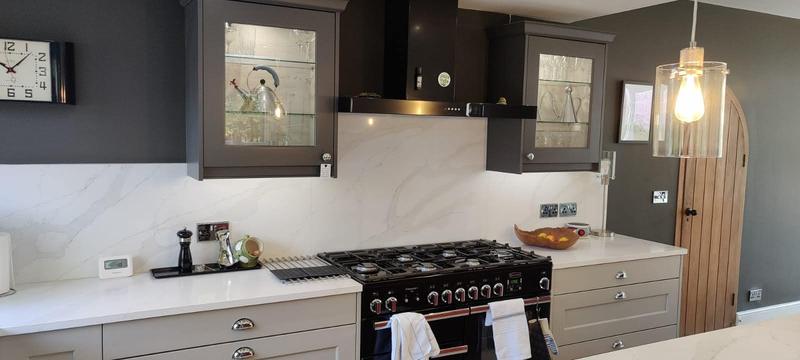 Shaker kitchen with a range cooker, marble-effect splashback and glazed wall cabinets