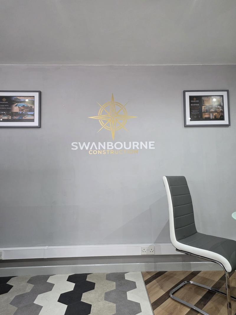 Swanbourne Construction compass logo on the showroom wall