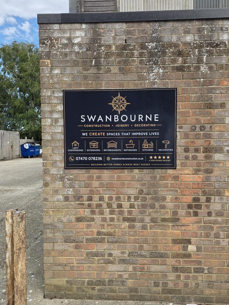 Swanbourne Construction sign on the brick end wall of the unit at Middleton Business Park