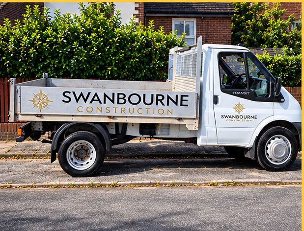 Swanbourne Construction tipper truck with a drop-side body, sign written on the cab door and the side board