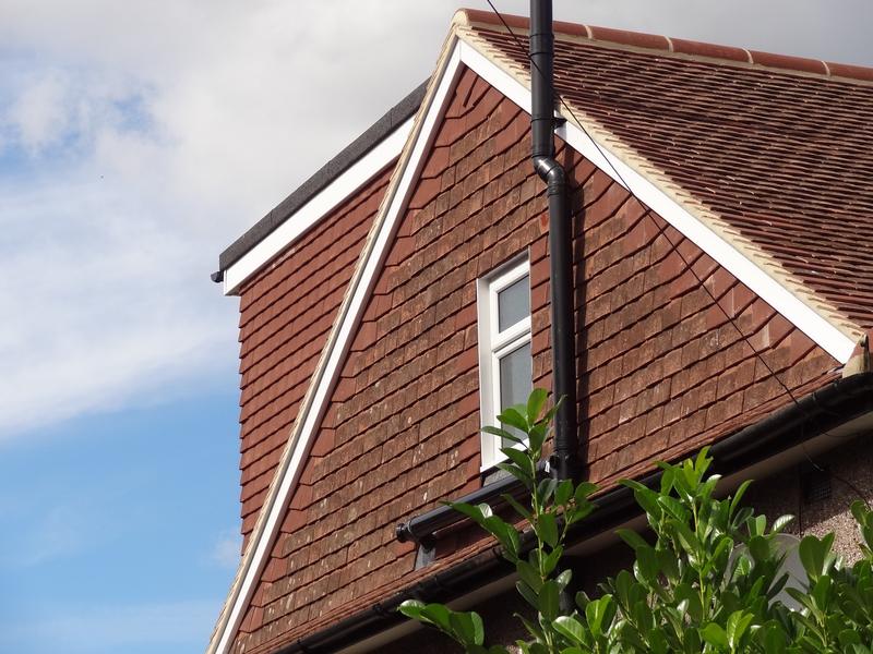 Tile-hung gable end with a window, the new roof tiled to match the existing house
